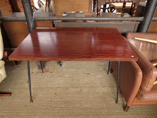 A 1950s kitchen table with a rosewood effect top and a stylised metal base