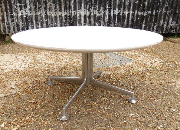 A white mellamine circular topped coffee table on an aluminium base