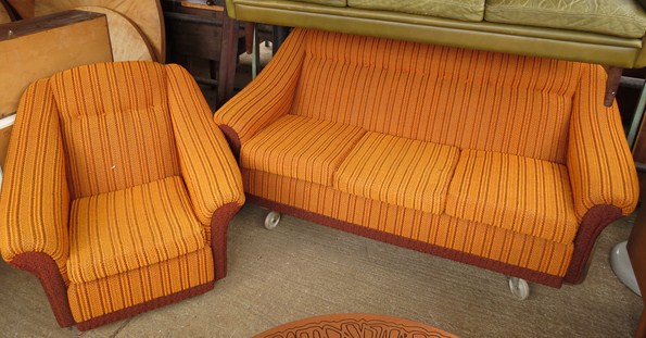 A 1960's three seater sofa and armchair in burnt orange colours