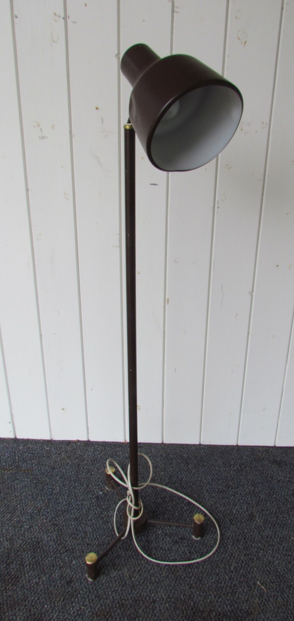 A brass and brown metal standard lamp on tri form base