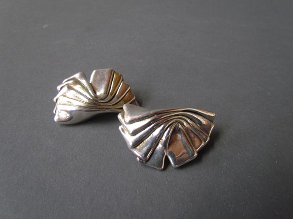 A pair of white metal clip on earrings of bow forms