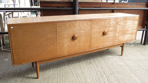 A 1970's oak finish side cabinet with twin folding doors, four interior drawers, raised on tapered