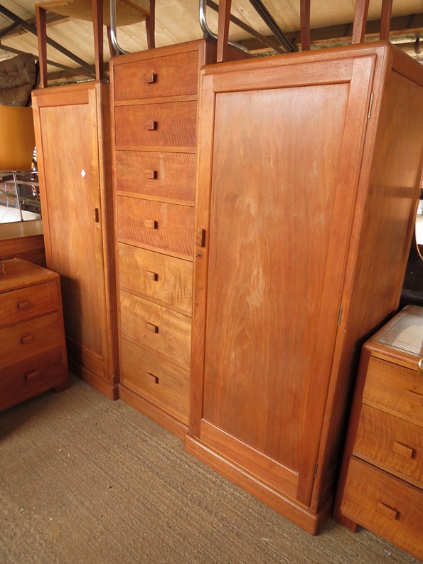 Betty Joel - a walnut bedroom suite comprising a twin wardrobe flanking seven drawers with stepped