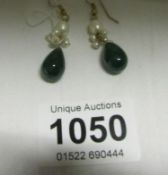 A pair of pearl and emerald drop earrings