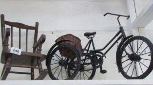 A doll's rocking chair and model tricycle