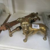 A brass door handle and a brass dog