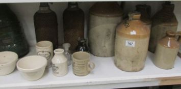 A mixed lot of stoneware bottles, enamel lampshades etc
