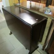 A dark oak drop leaf table