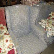 A wing armchair upholstered in fleur de lys pattern