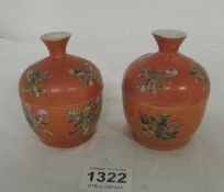 A pair of hand painted lidded pots