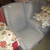 A wing armchair upholstered in fleur de lys pattern