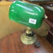 A brass study lamp with green glass shade