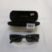 A pair of Gucci sunglasses in Gucci case