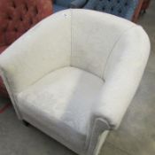 An ivory upholstered tub chair