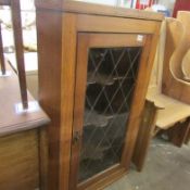 An oak corner cupboard with leaded door