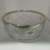 A large cut glass bowl with silver rim