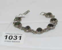 A silver bracelet set coloured stones