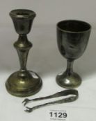 A silver candlestick, silver spill vase and silver sugar tongs