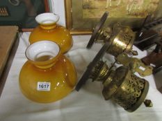 A pair of wall mounting brass oil lamps converted to electric