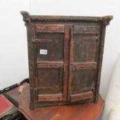 A small rustic corner cupboard