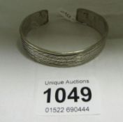 A silver open end bangle