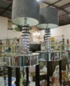 A pair of retro mirrored tables and lamps
