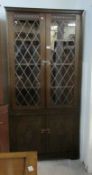 An oak leaded glazed corner cabinet