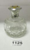 A silver topped perfume bottle bearing a Crest