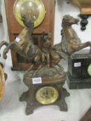 A spelter mantel clock surmounted 2 horses (glass a/f)