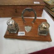 An oak inkstand with glass bottles and horse shoe pen stand