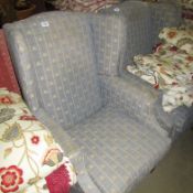 A wing armchair upholstered in fleur de lys pattern