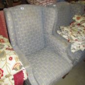 A wing armchair upholstered in fleur de lys pattern