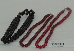 A black stone necklace and 2 red stone necklaces