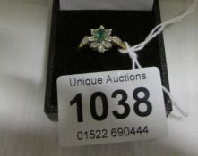 A 9ct gold ring set emerald and diamond cluster