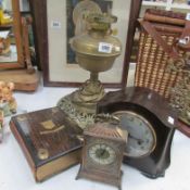 A brass lamp base, bakelite clock, carriage clock and photo album