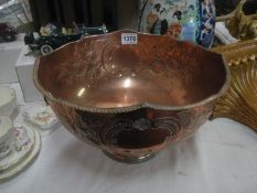 A copper punch bowl with lion head handles