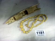 A carved necklace and one other item (possibly ivory)