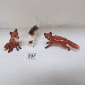 A Beswick hound and 2 foxes