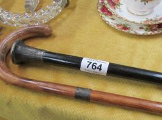 A silver topped walking stick and a cane