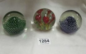 2 bubble and a floral glass paperweights