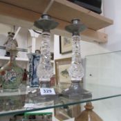 A pair of pewter tudric candlesticks with glass columns