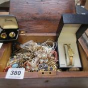 A wooden box of costume jewellery