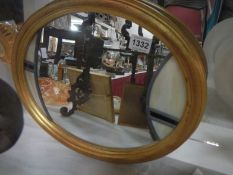 A gilt framed oval leaded glass mirror