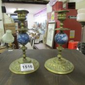 A pair of brass and glass candlesticks