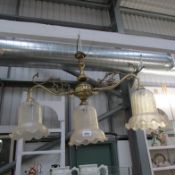 A 3 lamp brass ceiling light with glass shades