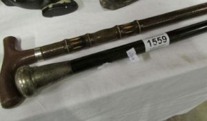 A silver topped walking stick and one other