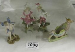 A pair of miniature porcelain figures  (1 a/f) and 2 bisque cherub figures