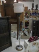 A tall chrome Art Deco table lamp with pink tinted Deco shade