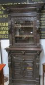 A carved oak glazed cabinet on base