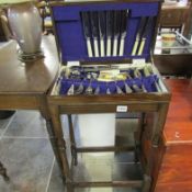 A canteen of cutlery on oak stand